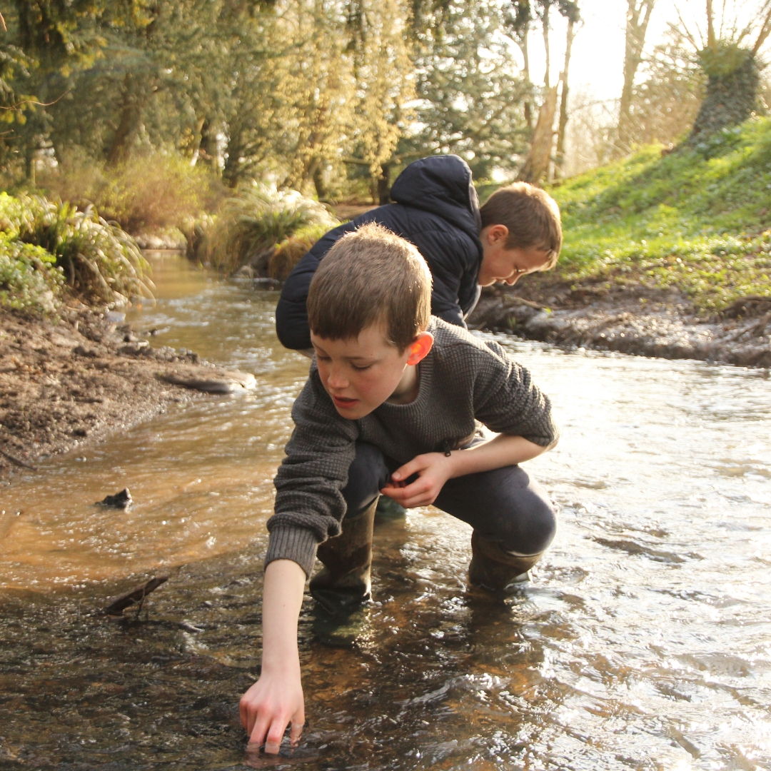Two young boys explore the creek.